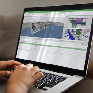 Structural BIM software displaying a detailed building model and project coordination tools on a laptop.